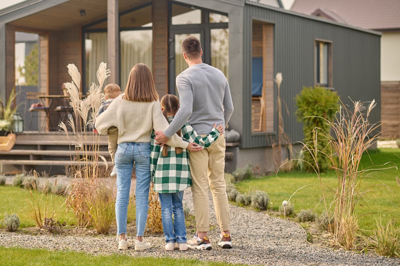 Family hugging while admiring their home
