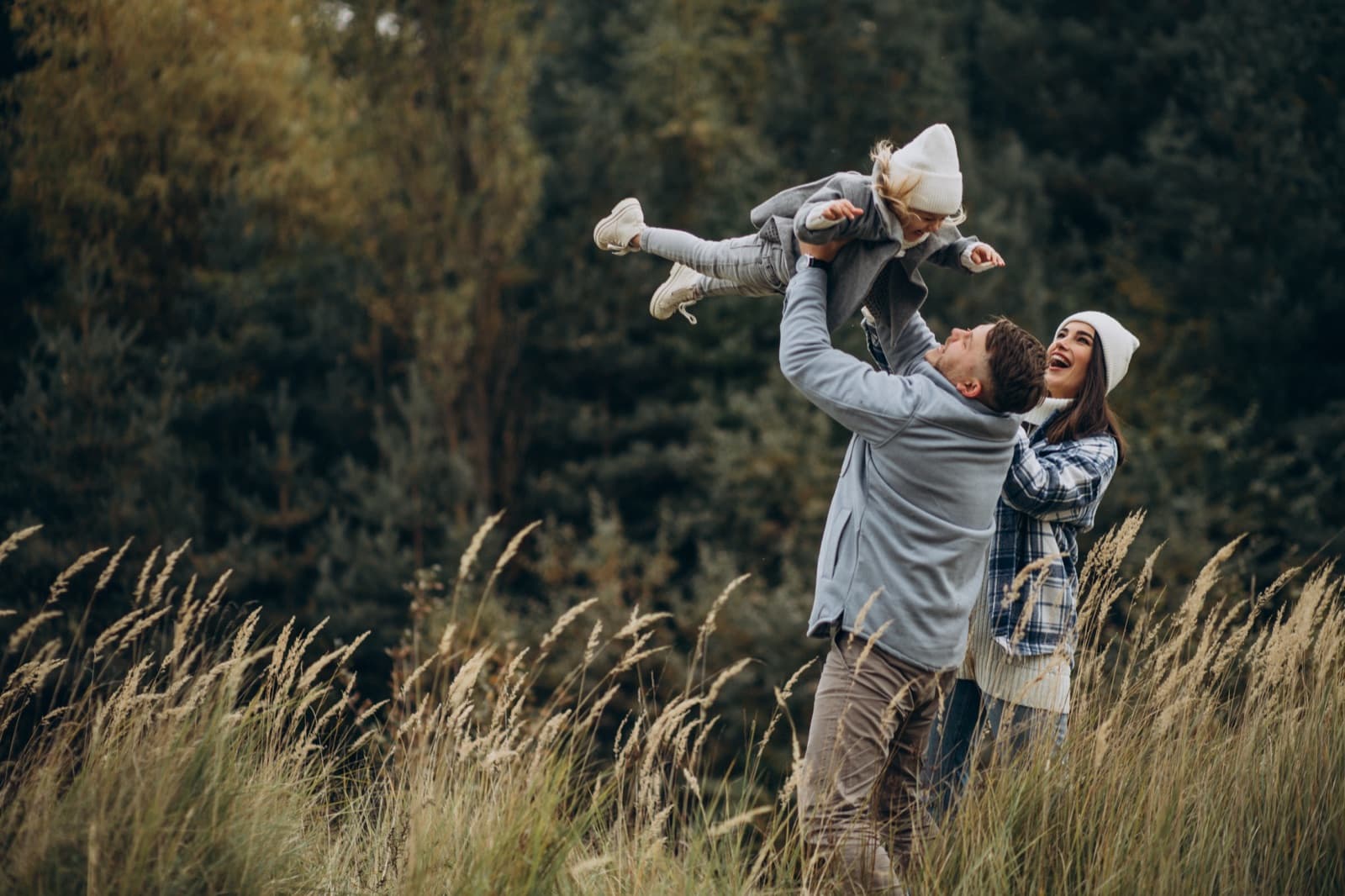 Family with their young daughter having fun outdoors in autumn